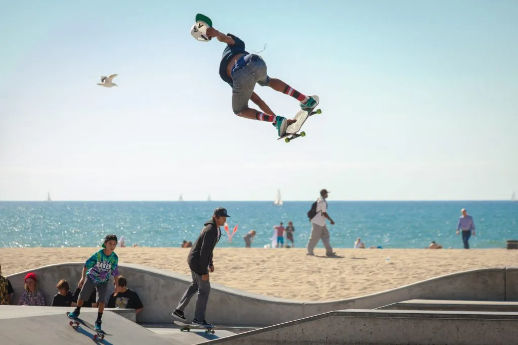 Outdoor skatepark near the sea with people skateboarding.