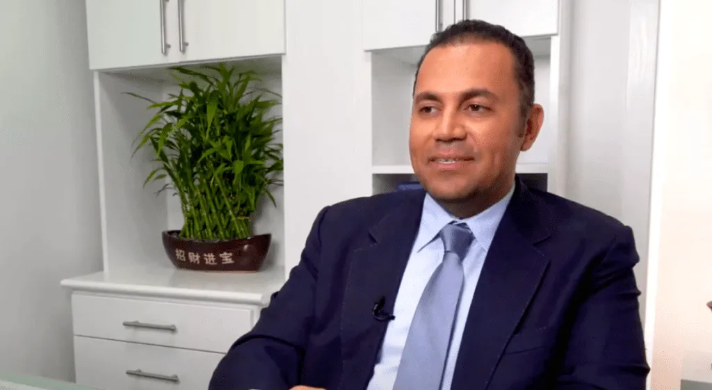 Smiling professional in an office setting at a plastic surgery center.