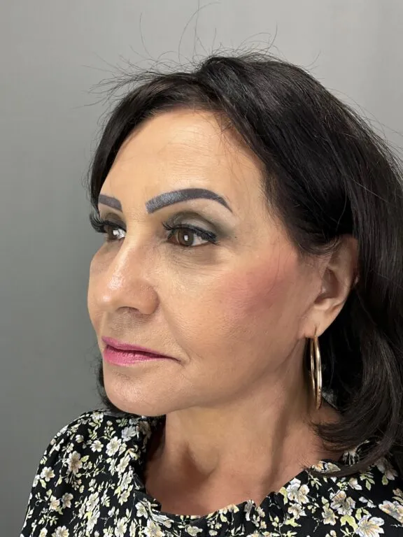 Side profile of woman with enhanced facial features and makeup.
