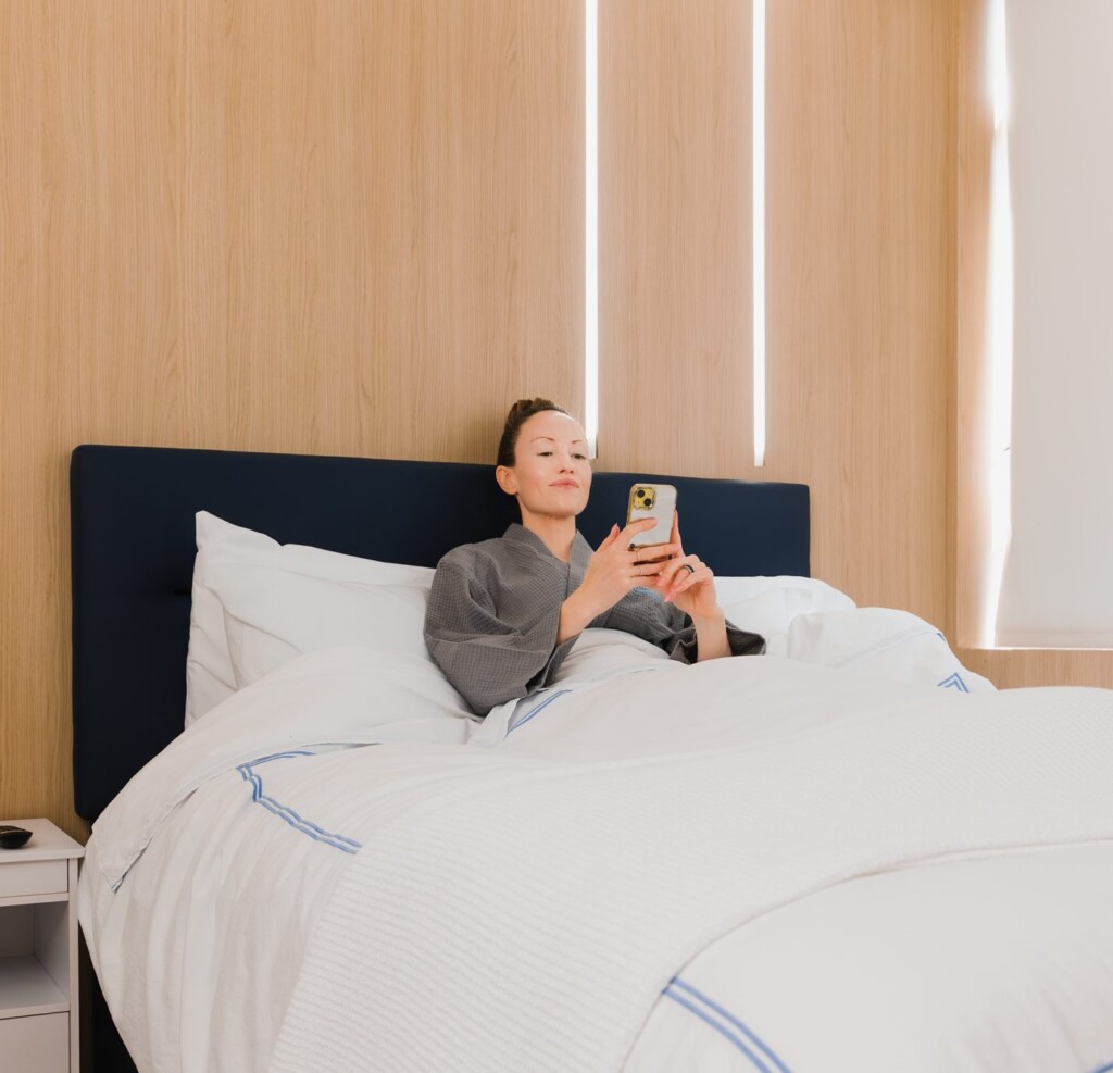 Woman relaxing in a recovery room bed at a plastic surgery center.