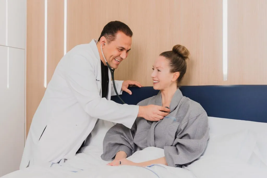 Doctor examining a smiling patient in a plastic surgery center.