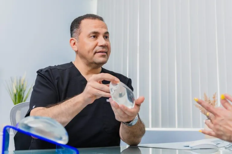 Doctor discussing breast implant options with a patient at a plastic surgery center.