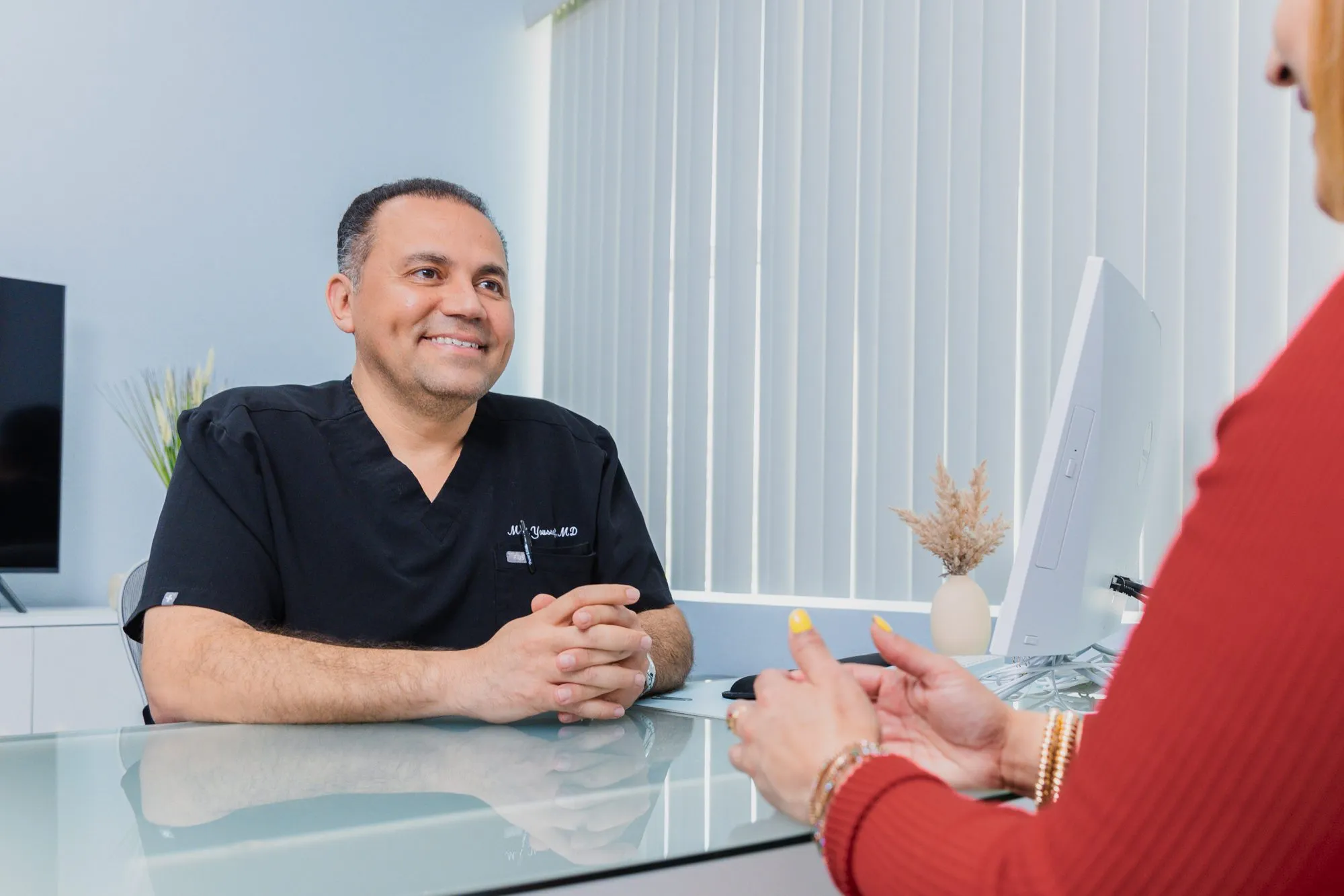 Plastic surgeon consulting with a patient in a modern office setting.