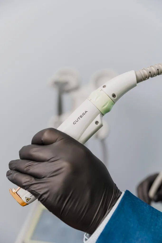 Close-up of a professional holding a laser device in a plastic surgery center.