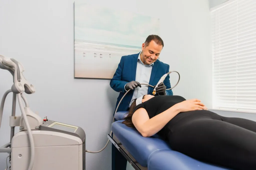 Doctor performing a cosmetic procedure on a patient in a plastic surgery center.