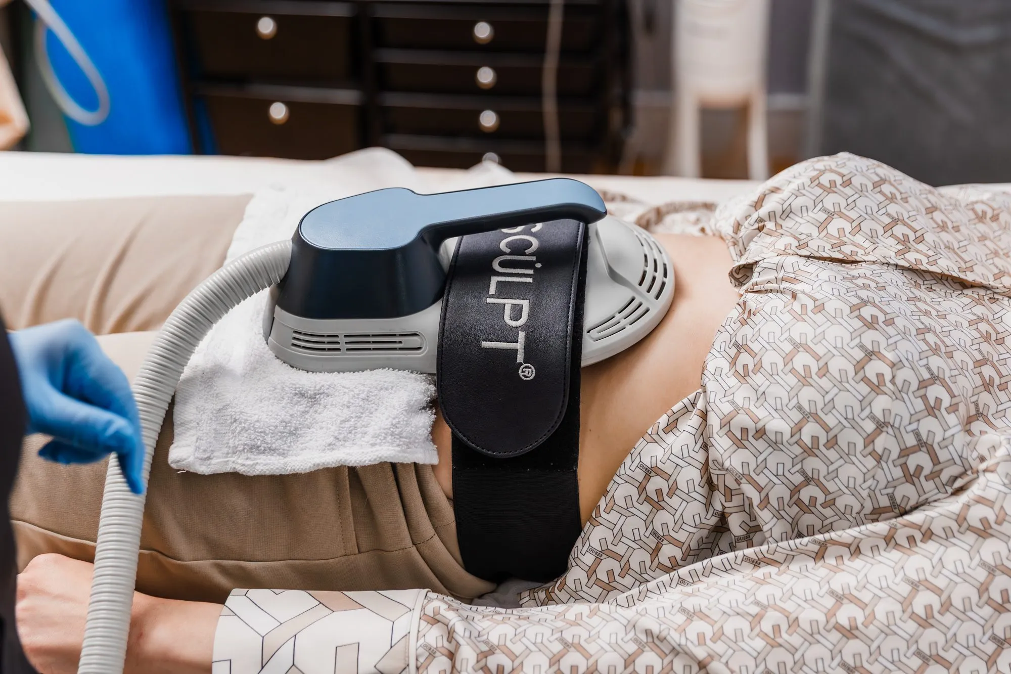 Non-invasive body contouring treatment in progress with EM sculpt device.