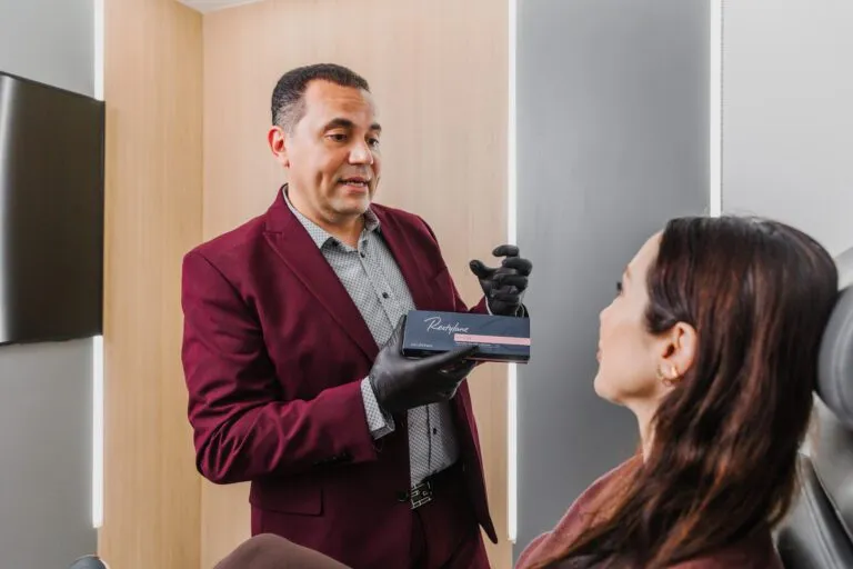 Doctor explaining Restylane product to patient at plastic surgery center.