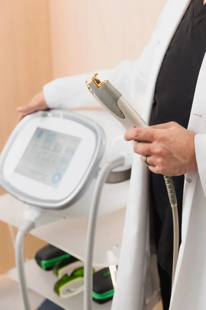 Doctor holding a laser device at a plastic surgery center.