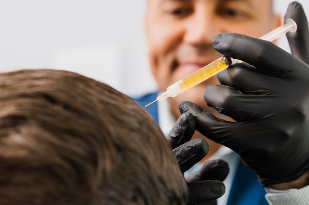 Doctor administering hair restoration injection in patient's scalp.