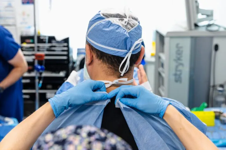 Surgeon in a sterile room preparing for plastic surgery.