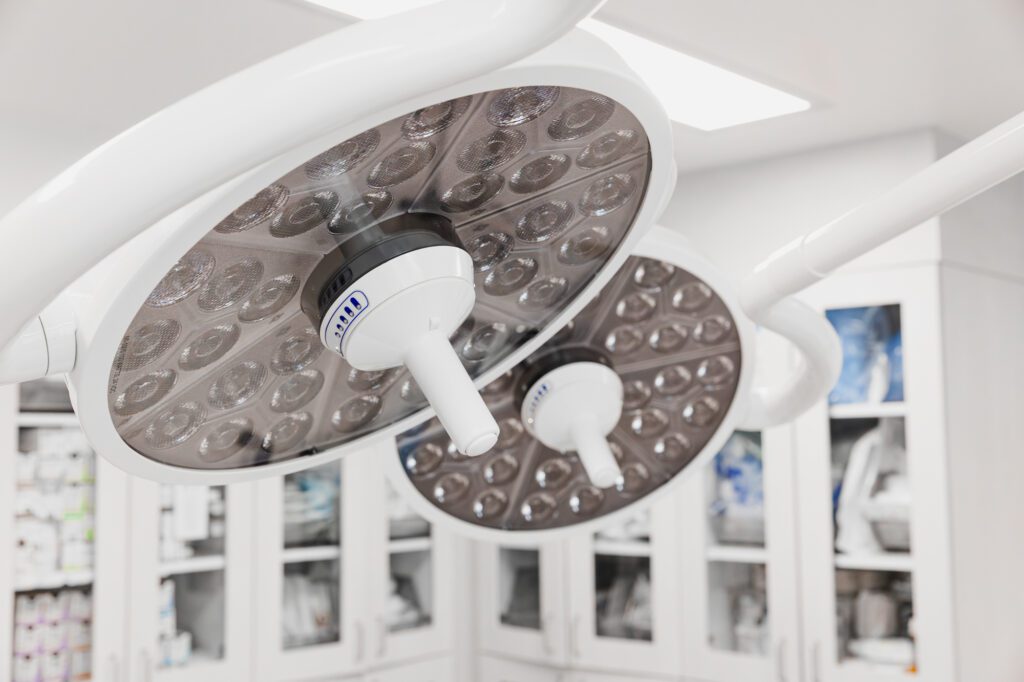 Modern surgical lights in a clean plastic surgery operating room.