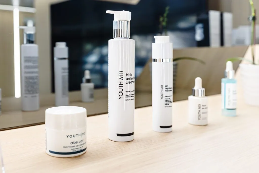 Skincare products on a wooden counter at a plastic surgery center.