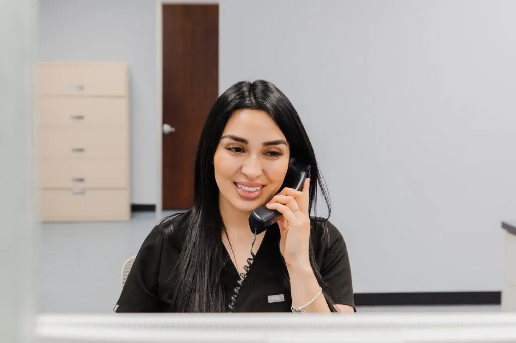 Receptionist answering phone at a plastic surgery center.