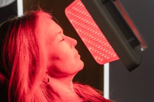 Woman receiving red light therapy at a plastic surgery center.