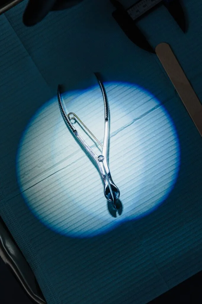 Surgical forceps on a blue surgical drape.