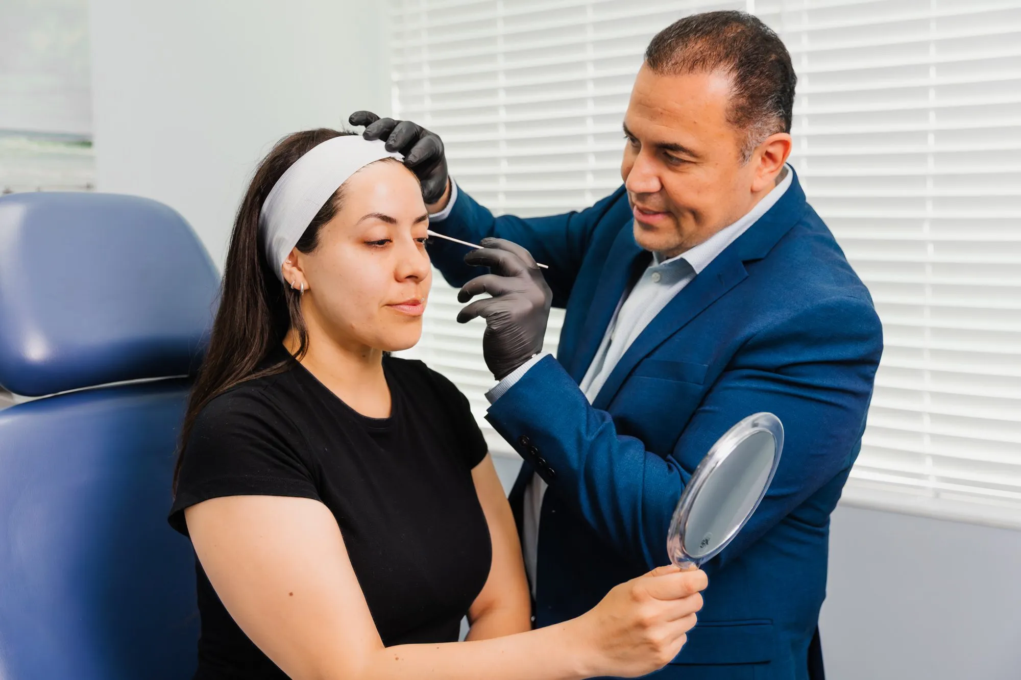 Doctor examining patient before cosmetic procedure at a plastic surgery center.