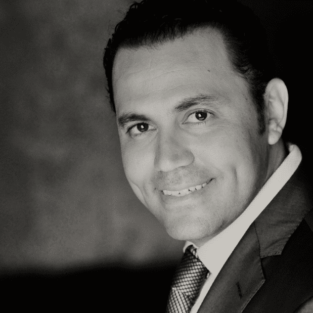 Smiling plastic surgeon in a white coat at a medical center.